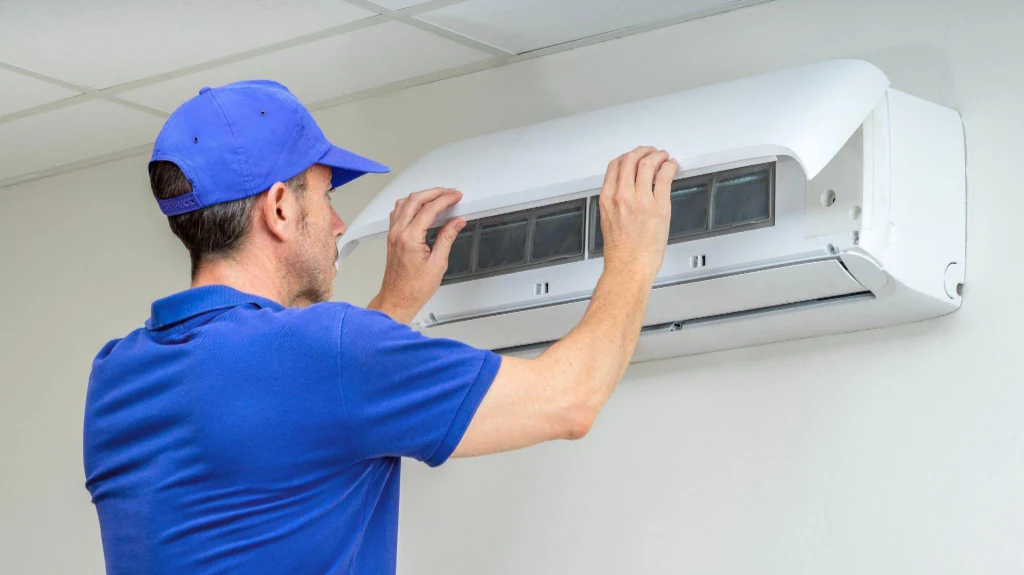 Technician servicing high-efficiency indoor heat pump unit in Cardiff-by-the-Sea