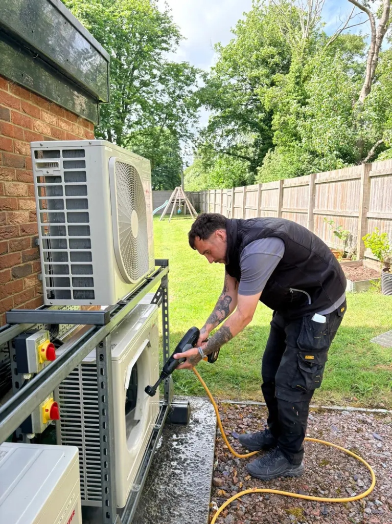 Certified technician pressure washing outdoor air conditioning condenser coils in La Costa, CA
