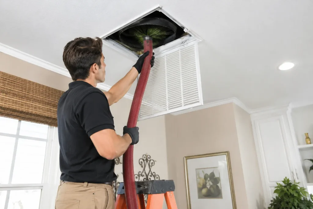 Carlsbad HVAC Pros technician vacuuming ceiling return ductwork in Rancho Bernardo
