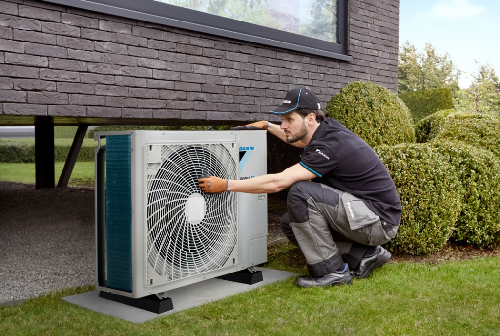 Technician tuning a high-efficiency Daikin inverter heat pump in San Marcos